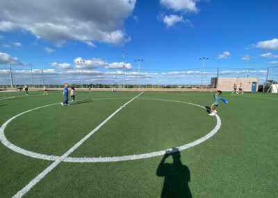 A picture of kids on the rooftop soccer field of the Princeton Club playing various games and a bright blue sky above.