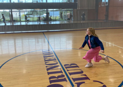 A picture of a little girl running inside the Princeton Club gymnasium.
